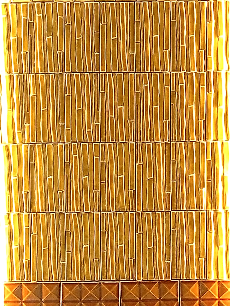 Dettaglio texture rivestimento ceramico tridimensionale effetto canne di bambù dorato di Barro